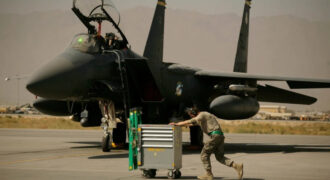 Un miembro de la Fuerza Aérea de Estados Unidos pasa empujando un carro por delante de un F-15E Strike Eagle en la Base Aérea de Bagram, en Afganistán, el 17 de octubre de 2009.AP/ Maya Alleruzzo