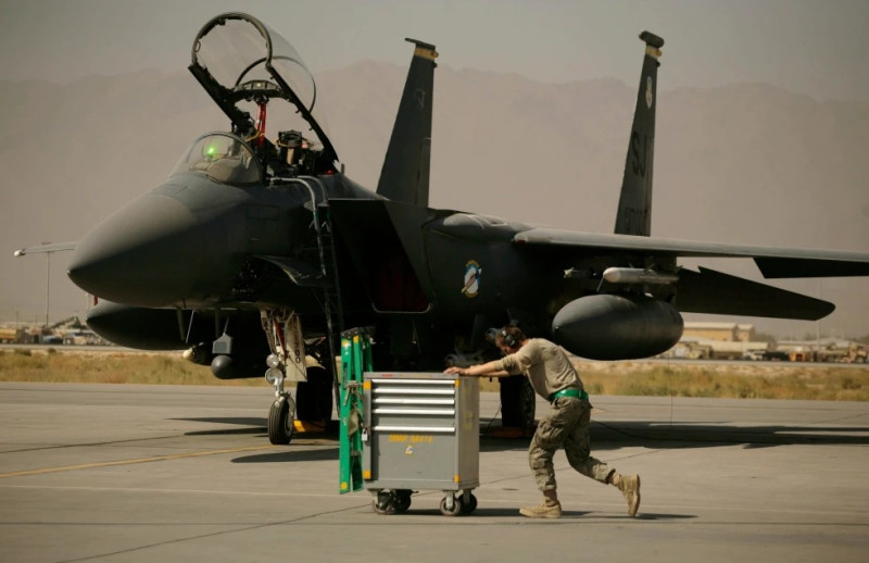 Un miembro de la Fuerza Aérea de Estados Unidos pasa empujando un carro por delante de un F-15E Strike Eagle en la Base Aérea de Bagram, en Afganistán, el 17 de octubre de 2009.AP/ Maya Alleruzzo